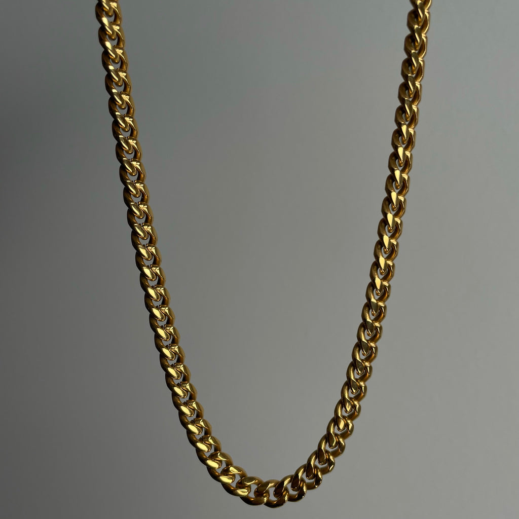 18K Gold PVD Plated Stainless Steel 6mm Cuban Chain. Also available in Stainless Steel. The perfect streetwear accessory for any outfit. Plated 5 times with 18K Gold, with a custom lobster clasp logo. Hypoallergenic, tarnish free and water resistant.