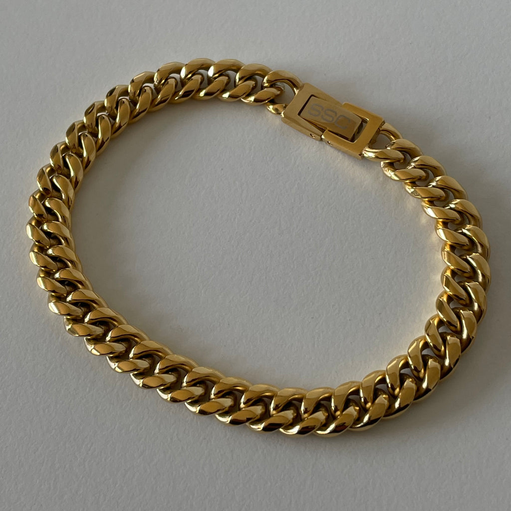 18K Gold PVD Plated Stainless Steel 8mm Cuban Bracelet. Also available in Stainless Steel. The perfect streetwear accessory for any outfit. Plated 5 times with 18K Gold, with a custom locked clasp logo. Hypoallergenic, tarnish free and water resistant.